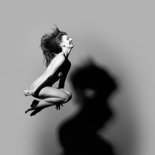 Aktfoto von springender junger Frau